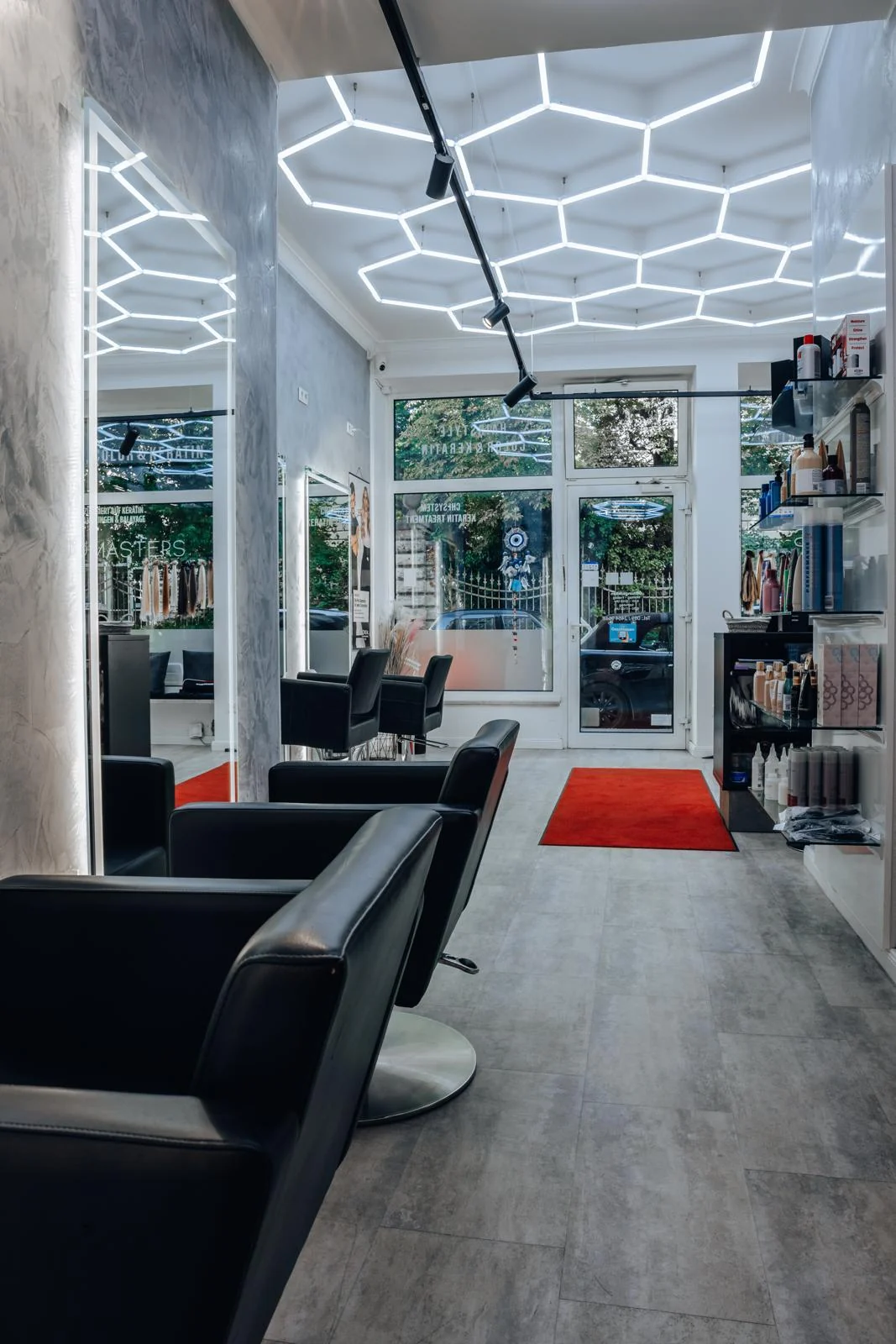 Salonperspektive mit beleuchteten Spiegeln und Stylingstühlen